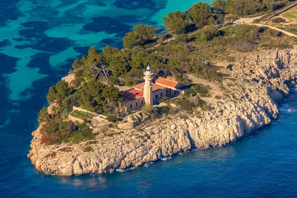 Pollenca from the bird's eye view: Lighthouse of the Faro de Punta de la Avanzada as a historic seafaring character in the coastal area in Pollenca in Balearische Insel Mallorca, Spain