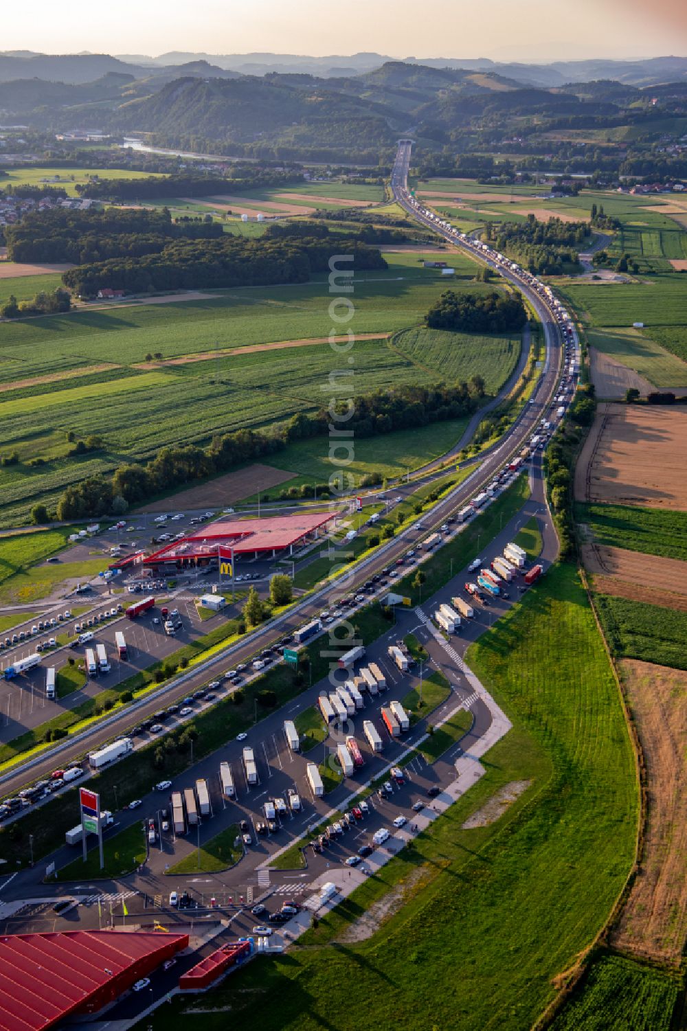Dogose from the bird's eye view: Lorries - parking spaces at the highway rest stop and parking of the motorway E59 with Maribor Petrol in Zrkovci in Upravna enota Maribor, Slovenia