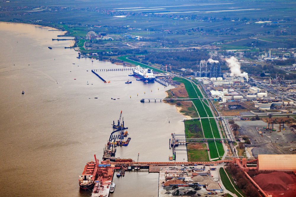 Stade from above - Water bridge with pipeline systems of the LNG natural gas and liquid gas terminal and unloading quay with the special ship Energos Force (formerly Transgas Force) docking on the banks of the Elbe in the district of Buetzfleth in Stade in the state Lower Saxony, Germany