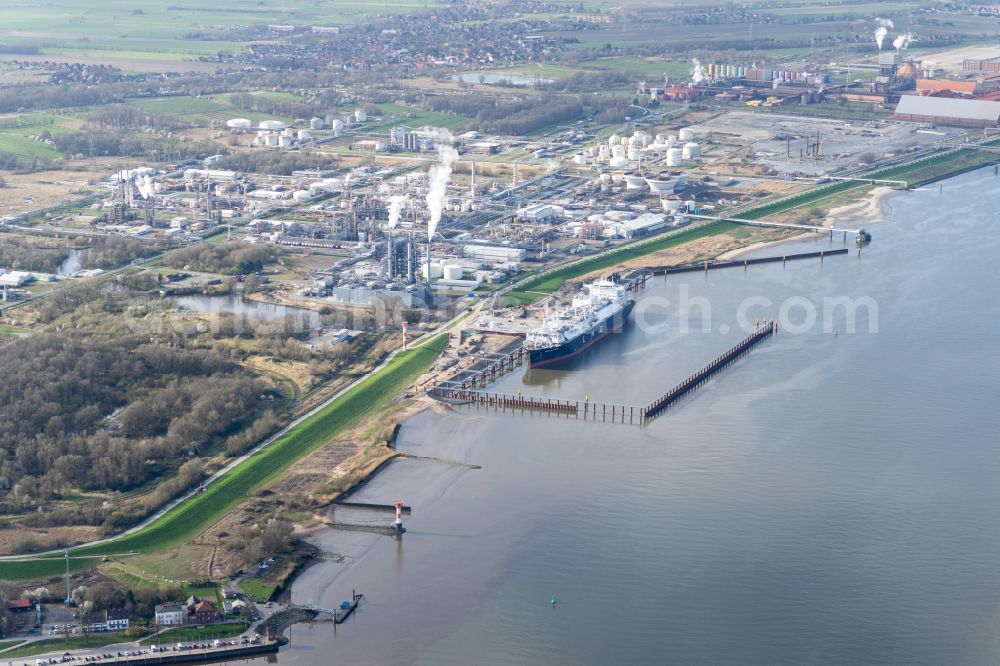 Aerial image Stade - Water bridge with pipeline systems of the LNG natural gas and liquid gas terminal and unloading quay with the special ship Energos Force (formerly Transgas Force) docking on the banks of the Elbe in the district of Buetzfleth in Stade in the state Lower Saxony, Germany