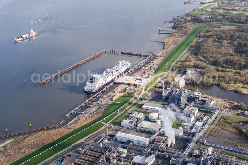 Aerial image Stade - Water bridge with pipeline systems of the LNG natural gas and liquid gas terminal and unloading quay with the special ship Energos Force (formerly Transgas Force) docking on the banks of the Elbe in the district of Buetzfleth in Stade in the state Lower Saxony, Germany