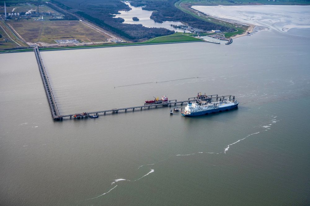 Hooksiel from above - Water bridge with line systems of the LNG natural gas and liquid gas terminal and unloading dock when unloading the Hoeegh Esperanza an LNG storage and evaporation ship in Hooksiel in the state Lower Saxony, Germany