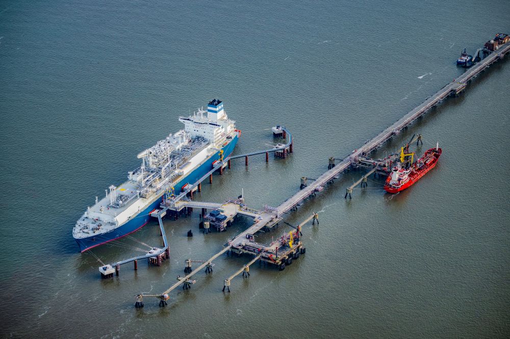 Aerial photograph Hooksiel - Water bridge with line systems of the LNG natural gas and liquid gas terminal and unloading dock when unloading the Hoeegh Esperanza an LNG storage and evaporation ship in Hooksiel in the state Lower Saxony, Germany