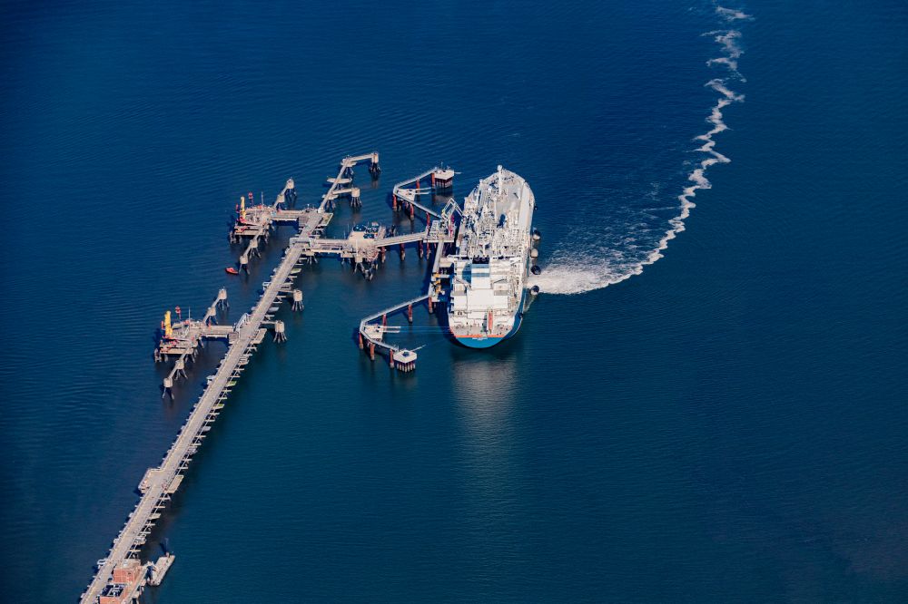Wangerland from the bird's eye view: Water bridge with line systems of the LNG natural gas and liquid gas terminal and unloading dock when unloading the Hoeegh Esperanza an LNG storage and evaporation ship in Hooksiel in the state Lower Saxony, Germany
