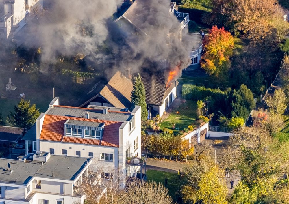 Mülheim an der Ruhr from the bird's eye view: Fire fighting at the fire brigade on fire the building on single family house on Bergerstrasse in the district Menden in Muelheim on the Ruhr in the state North Rhine-Westphalia, Germany