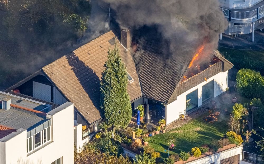 Aerial photograph Mülheim an der Ruhr - Fire fighting at the fire brigade on fire the building on single family house on Bergerstrasse in the district Menden in Muelheim on the Ruhr in the state North Rhine-Westphalia, Germany