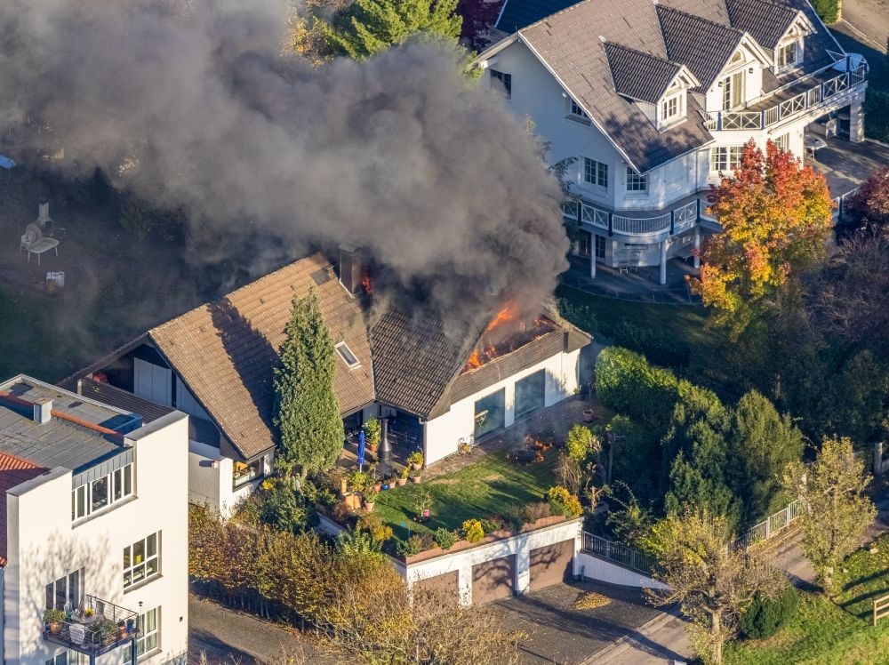 Mülheim an der Ruhr from above - Fire fighting at the fire brigade on fire the building on single family house on Bergerstrasse in the district Menden in Muelheim on the Ruhr in the state North Rhine-Westphalia, Germany