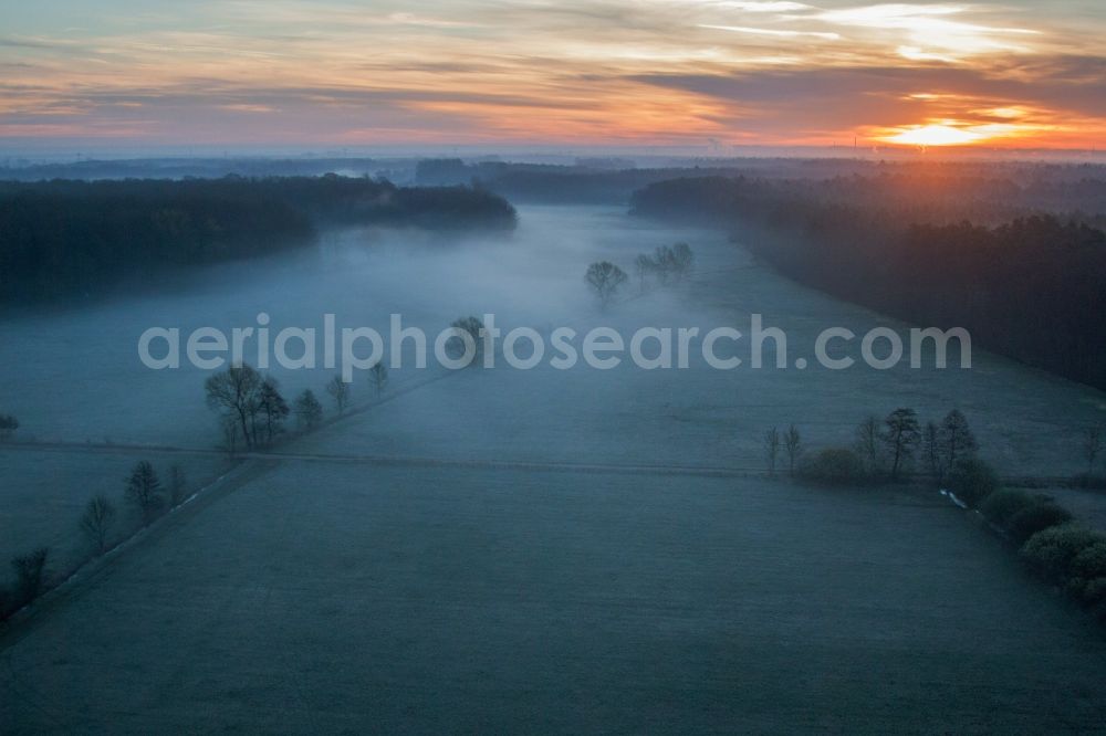 Minfeld from the bird's eye view: Sunrise haze at structures of a field landscape Otterbachtal in Minfeld in the state Rhineland-Palatinate