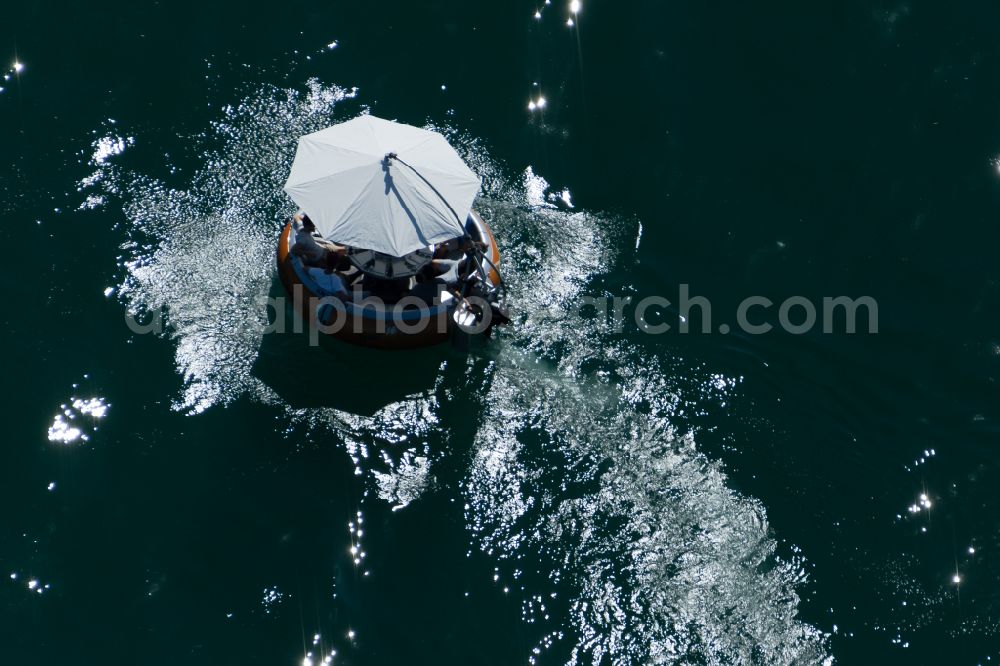 Bodman-Ludwigshafen from the bird's eye view: Motorboat - Badeinsel with a parasol in motion in Bodman-Ludwigshafen at Bodensee in the state Baden-Wuerttemberg, Germany