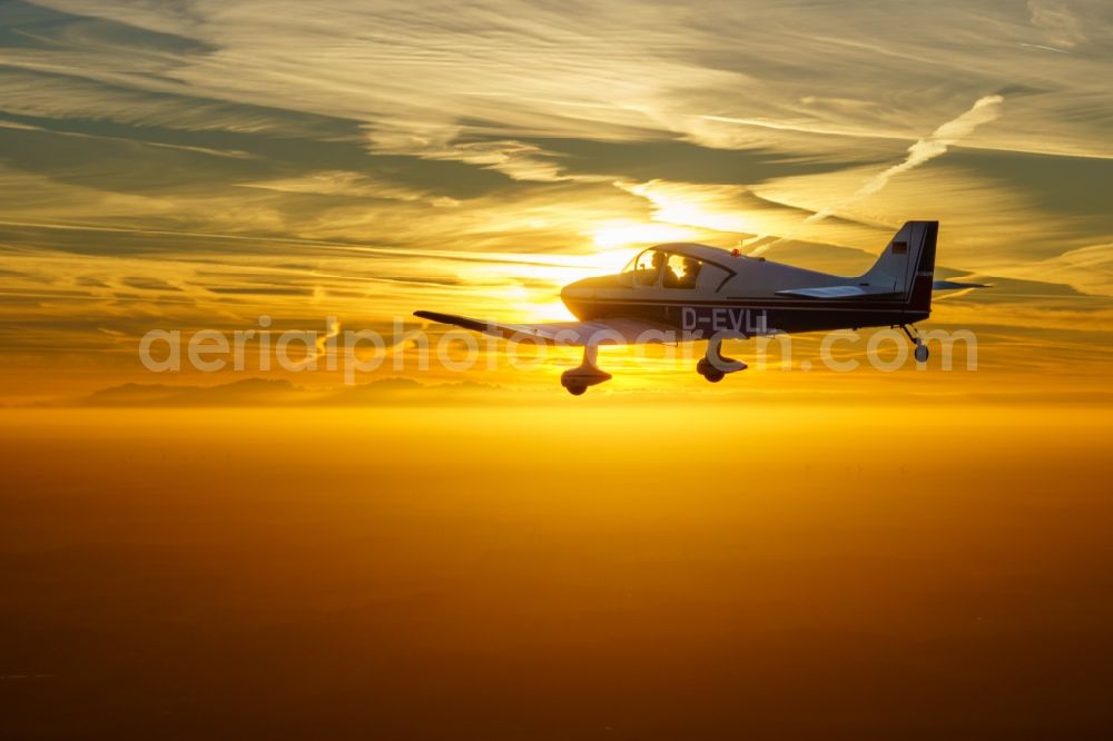 Bremervörde from the bird's eye view: Four-seater sports aircraft DR250 / 160 D-EVLL Aircraft in flight while sunset over the airspace in Bremervoerde in the state Lower Saxony, Germany