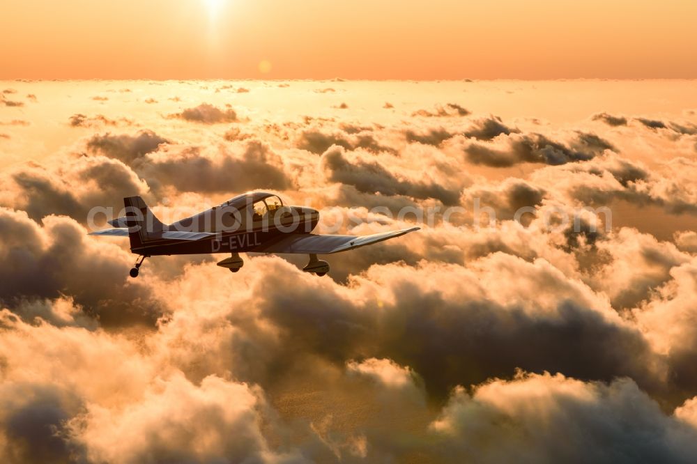 Aerial image Cuxhaven - Motor aircraft and sports aircraft flying above clouds in the evening light of sunset over the airspace in Cuxhaven in the federal state of Lower Saxony, Germany