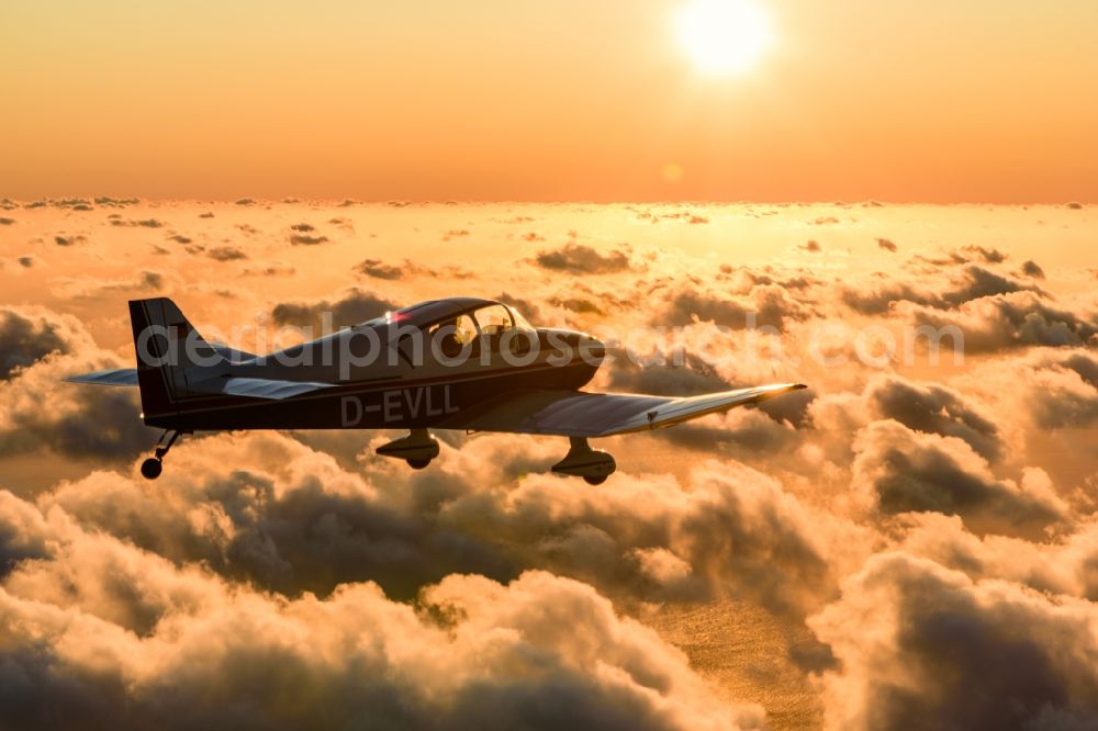 Aerial image Cuxhaven - Motor aircraft and sports aircraft flying above clouds in the evening light of sunset over the airspace in Cuxhaven in the federal state of Lower Saxony, Germany