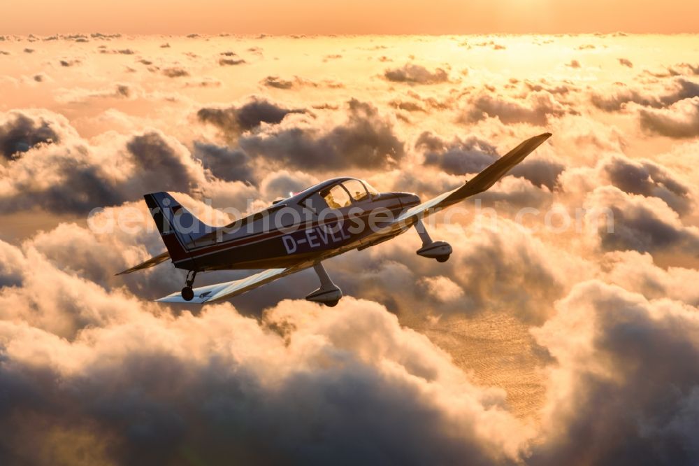 Aerial photograph Cuxhaven - Motor aircraft and sports aircraft flying above clouds in the evening light of sunset over the airspace in Cuxhaven in the federal state of Lower Saxony, Germany