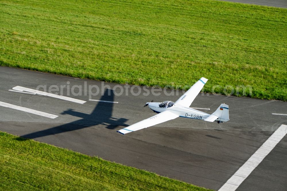 Stade from above - Powered glider aircraft Scheibe SF-25 in landing approach for landing at the airport in Stade in the state Lower Saxony, Germany