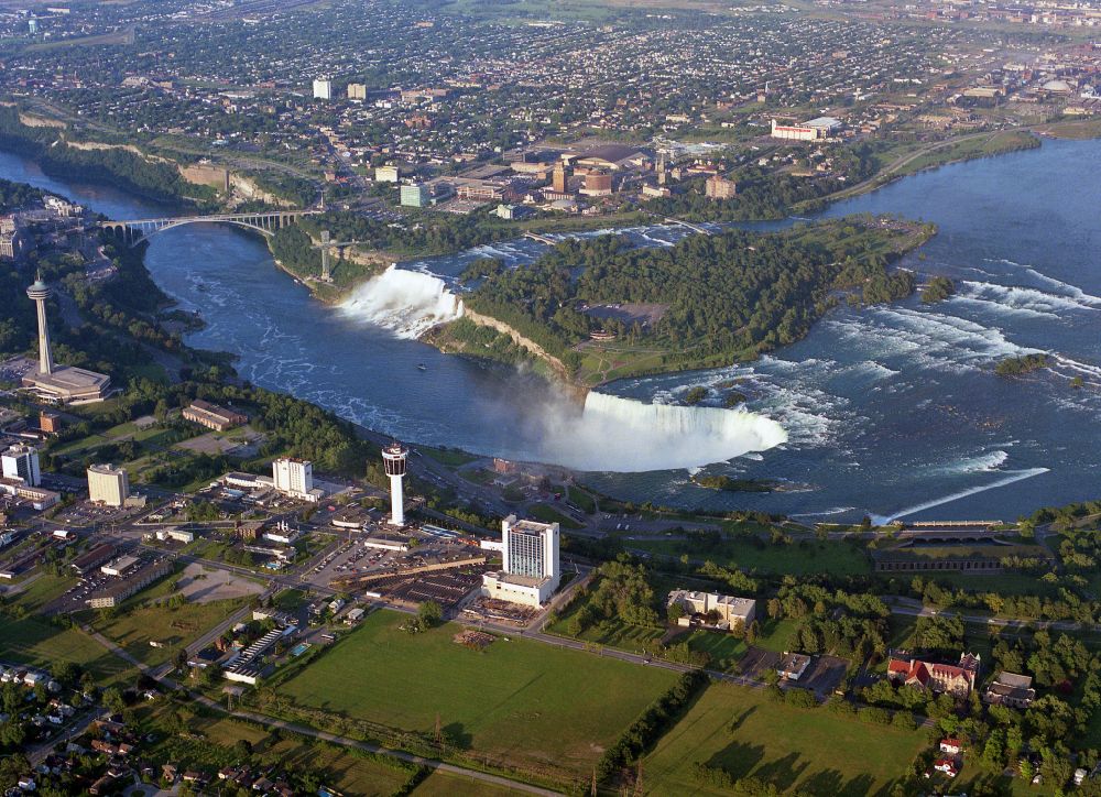 Niagara Falls from the bird's eye view: Natural spectacle of the Niagara Falls on Niagara River on street Niagara River Parkway in Niagara Falls in Ontario, Canada. The larger Horseshoe Falls in Canada and the American Falls in the United States