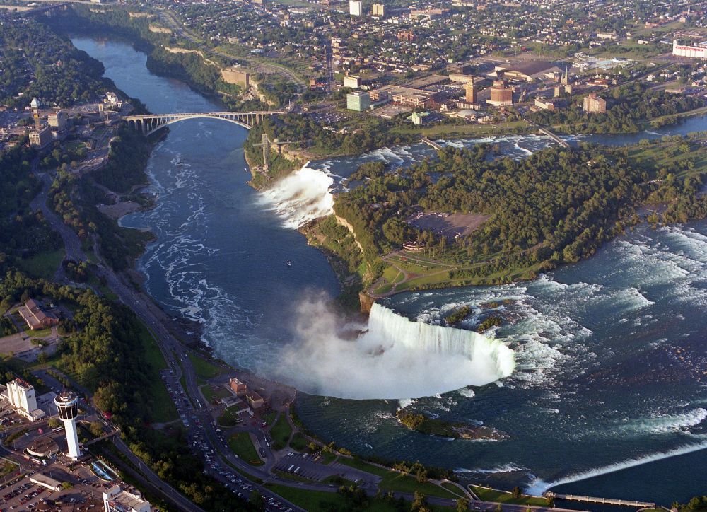 Niagara Falls from the bird's eye view: Natural spectacle of the Niagara Falls on Niagara River on street Niagara River Parkway in Niagara Falls in Ontario, Canada. The larger Horseshoe Falls in Canada and the American Falls in the United States
