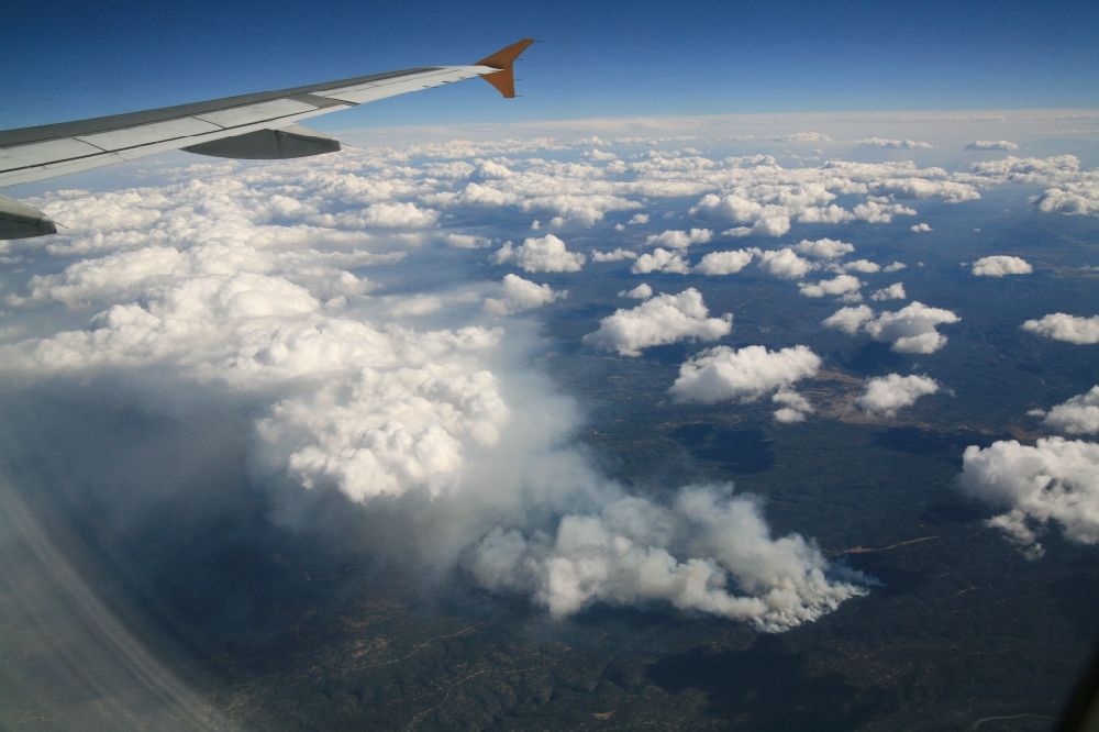Ganado from above - Forest fire near Ganado in US on the Navajo National Reserve. From the airliner you can see how the conflagration influenced the formation of clouds