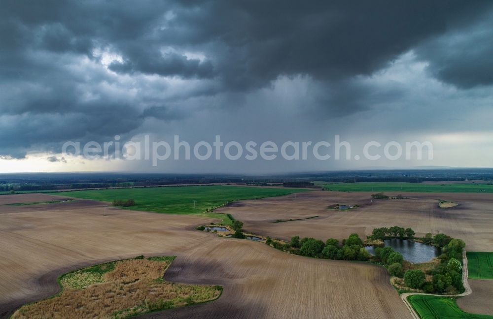 Jacobsdorf from above - Rain clouds with falling precipitation for the natural irrigation of the agricultural fields in Jacobsdorf in the state Brandenburg, Germany