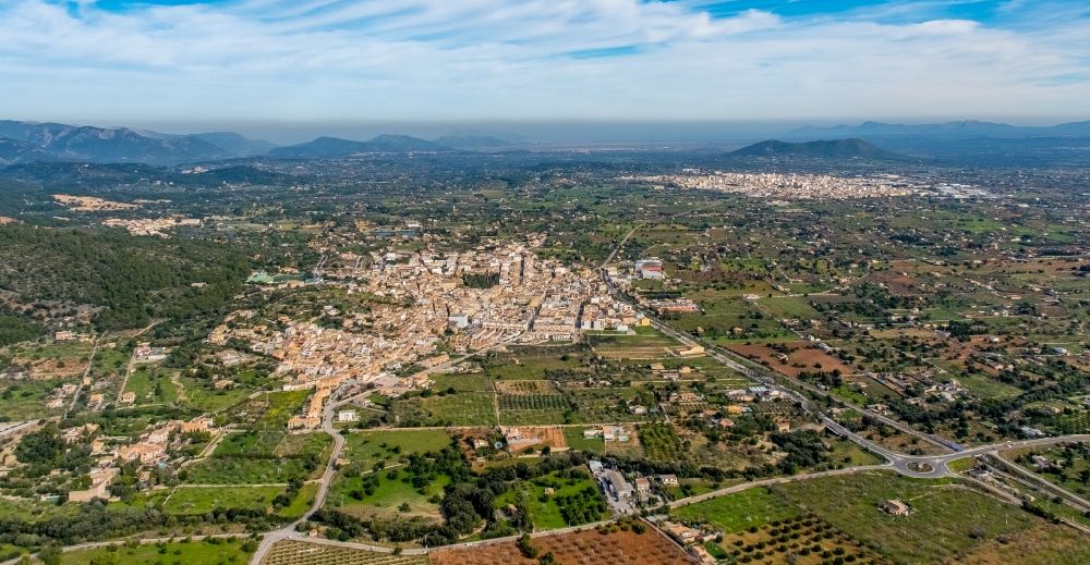 Lloseta from the bird's eye view: Town view of the streets and houses of the residential areas in Lloseta with Inca in the background in Balearic island Mallorca, Spain
