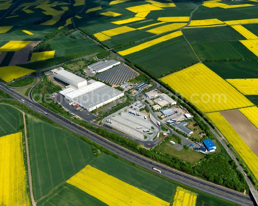 Aerial photograph Mayen - View of the industrial area of Mayen in the state of Rhineland-Palatinate. The industrial area with its halls and factories is located on the federal motorway A48 in the county district of Mayen-Koblenz and surrounded by meadows and rapeseed fields
