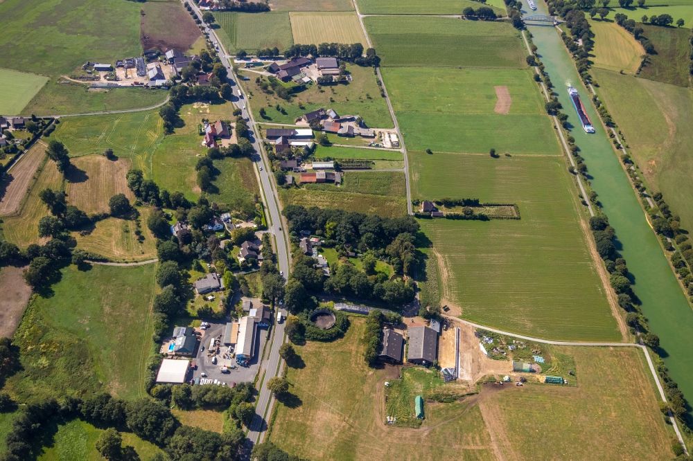 Hünxe from the bird's eye view: Village view on the edge of agricultural fields and land overlooking the Gerd Goch Spirituosen-Fabrik Guenter Goch along the Weseler Str. and the Wesel-Datteln-Kanal in Huenxe in the state North Rhine-Westphalia, Germany