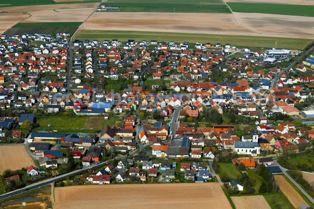 Unterpleichfeld from above - Town view with streets, houses and residential areas on the edge of agricultural fields and usable areas in Unterpleichfeld in the state Bavaria, Germany