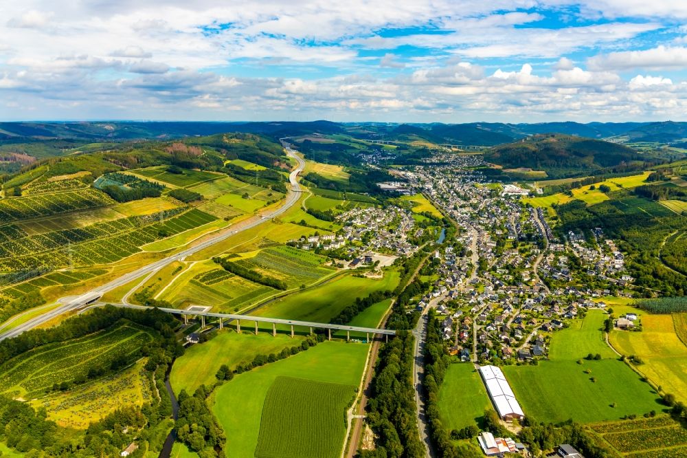 Aerial image Bestwig - Location view of the streets and houses of residential areas in the valley landscape surrounded by mountains with the bridge structures of the Ruhrtalbruecke Velmede and the Talbruecke Schormecke in the district Velmede in Bestwig in the state North Rhine-Westphalia, Germany