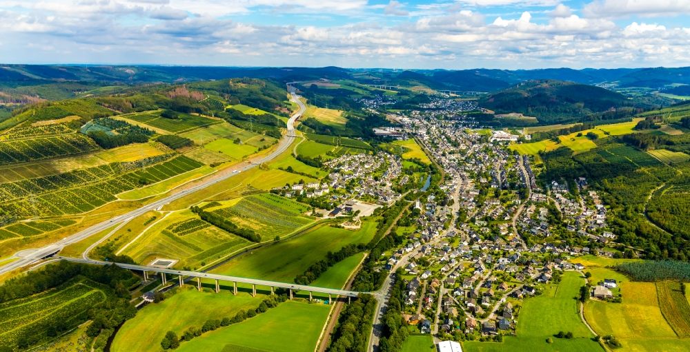 Aerial photograph Bestwig - Location view of the streets and houses of residential areas in the valley landscape surrounded by mountains with the bridge structures of the Ruhrtalbruecke Velmede and the Talbruecke Schormecke in the district Velmede in Bestwig in the state North Rhine-Westphalia, Germany