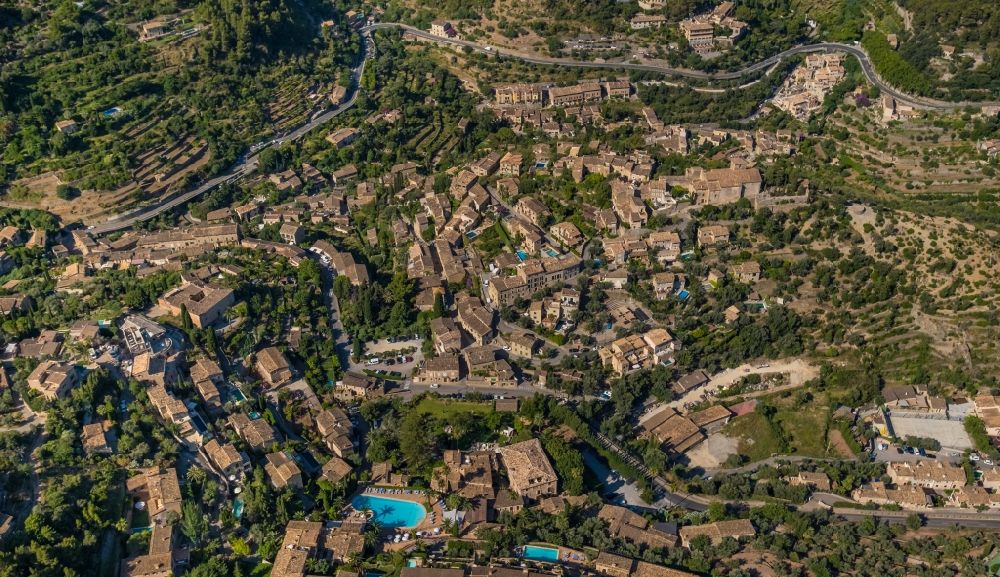 Deia from above - Location view of the streets and houses of residential areas in the valley landscape surrounded by mountains and forest in Deia in Balearic island of Mallorca, Spain