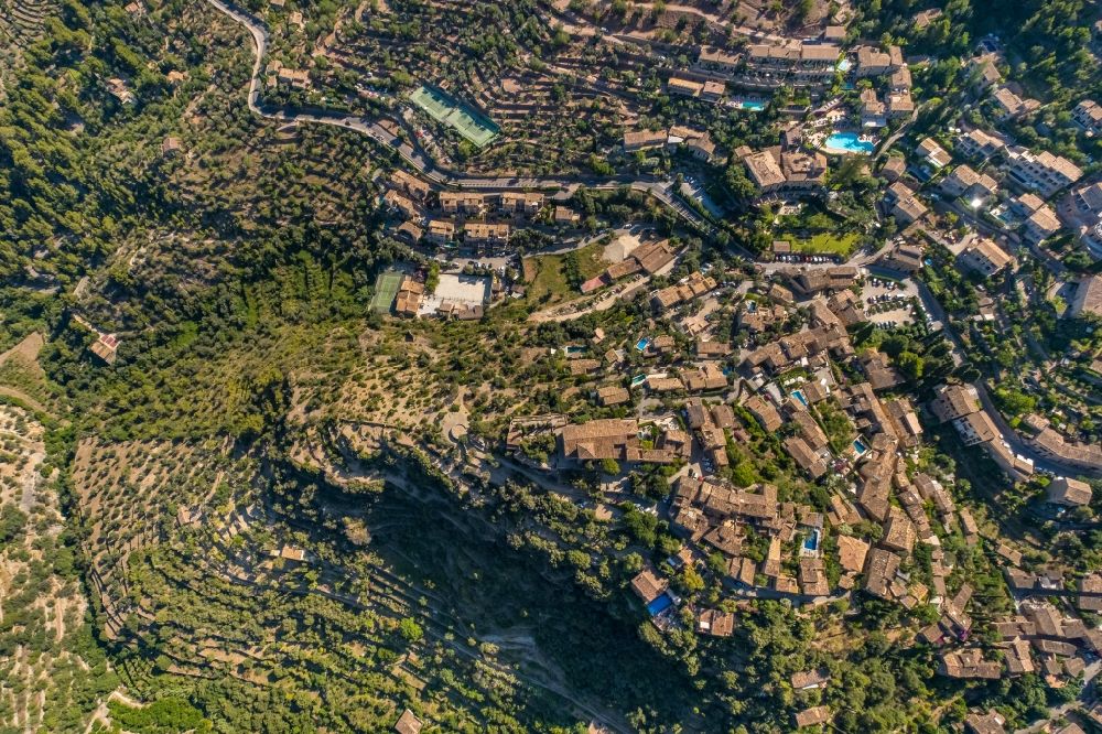 Deia from the bird's eye view: Location view of the streets and houses of residential areas in the valley landscape surrounded by mountains and forest in Deia in Balearic island of Mallorca, Spain
