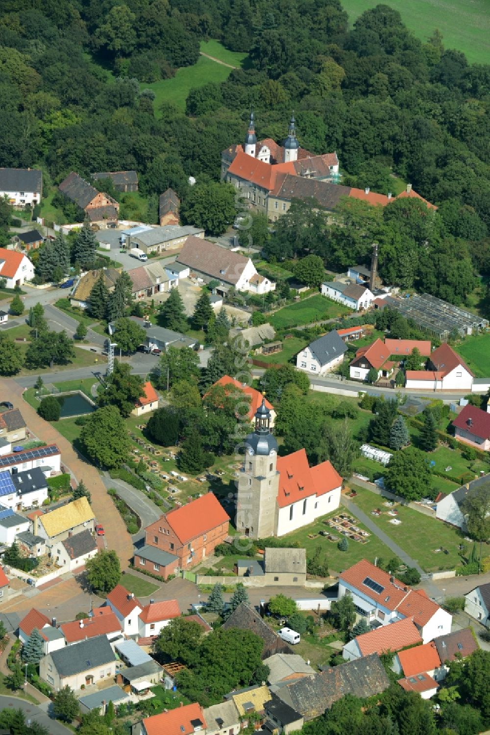 Aerial photograph Zschepplin - View of the borough of Zschepplin in the state of Saxony. The borough is located in the county district of North Saxony, surrounded by hills and fields and consists of residential buildings. The church St.Lucia is located in its centre and Castle Zschepplin on the edge of the borough