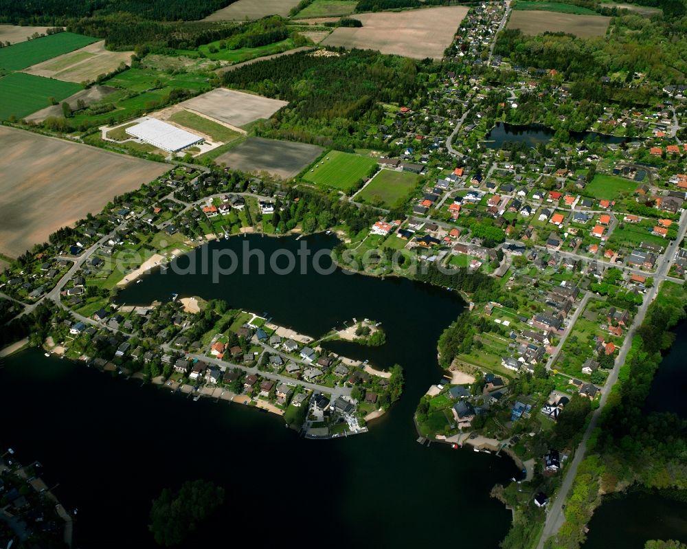 Güster from the bird's eye view: Village on the banks of the area lake of Pruesssee in Guester in the state Schleswig-Holstein, Germany