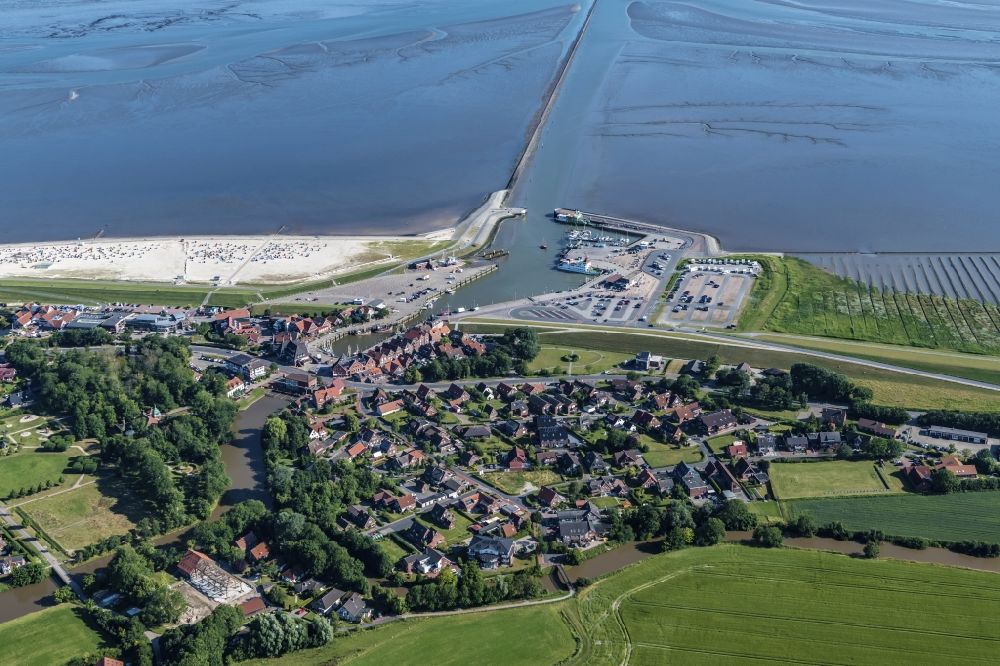 Aerial photograph Neuharlingersiel - East Frisian Coast in Neuharlingersiel in the state of Lower Saxony. The borough of Neuharlingersiel is located in Harlinger Land in East Frisia on the North Sea shore. The coastal line consists of the Lower Saxony Wadden Sea which has been named a UNESCO world heritage site in 2009. The landscape is characterised by Wadden Sea, agriculture and fields