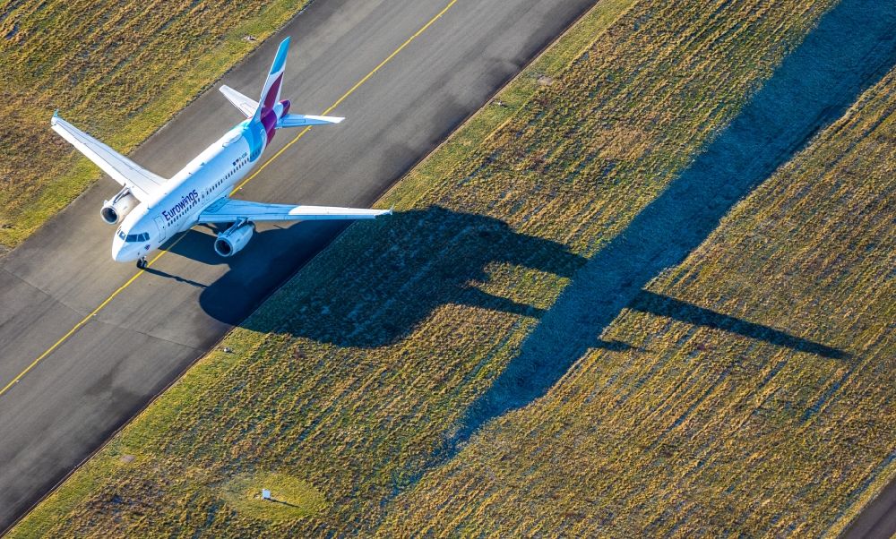 Dortmund from the bird's eye view: Airliner - Passenger aircraft call sign D-AGWK - Airbus A319-132 of Fluggesellschaft Eurowings at the start and climb over the airport in Dortmund in the state North Rhine-Westphalia, Germany