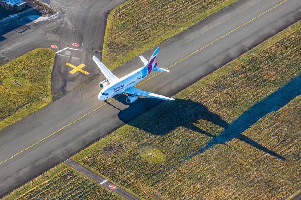 Aerial image Dortmund - Airliner - Passenger aircraft call sign D-AGWK - Airbus A319-132 of Fluggesellschaft Eurowings at the start and climb over the airport in Dortmund in the state North Rhine-Westphalia, Germany