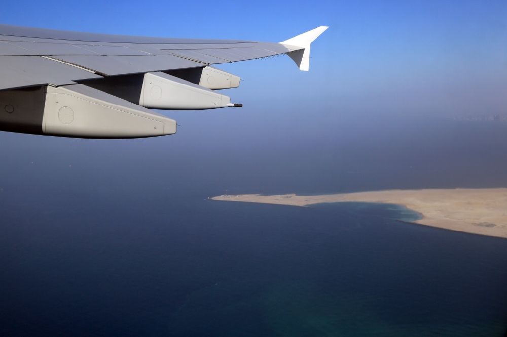 Aerial photograph Dubai - Airliner - Passenger aircraft Airbus A380 climbing out to the west over the Deira Islands in the Persian Gulf in Dubai in United Arab Emirates. The artificial landfill islands give space for 30 000 people and expands the coastline with 21 kilometres of beaches