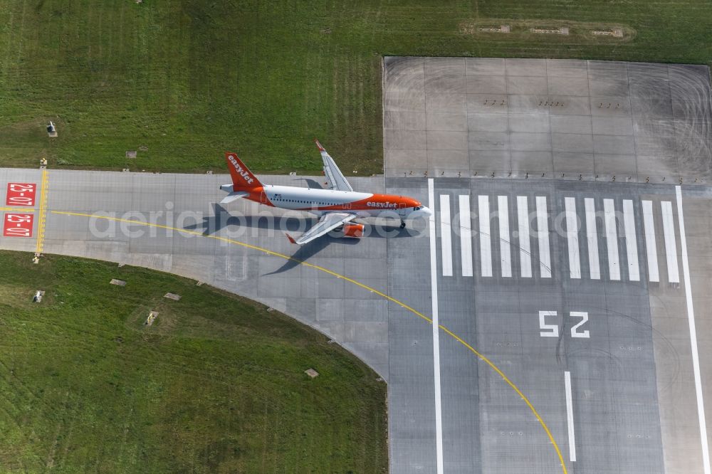 Aerial photograph Filderstadt - Passenger aircraft with the registration OE-IJS of the airline easyJet Europe of the type Airbus A320-200 taking off at Stuttgart Airport in Filderstadt in the state Baden-Wuerttemberg, Germany