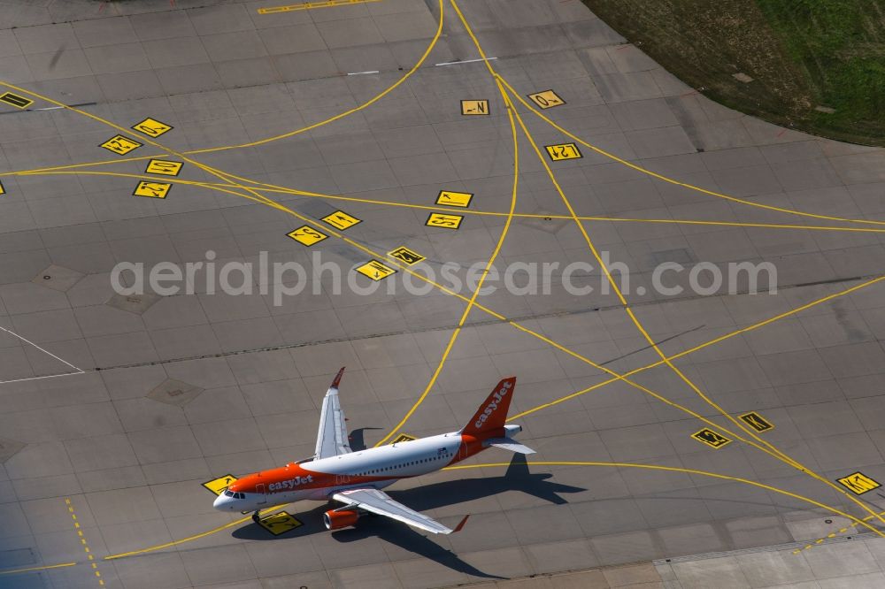 Aerial photograph Filderstadt - Passenger aircraft with the registration OE-IJS of the airline easyJet Europe of the type Airbus A320-200 taking off at Stuttgart Airport in Filderstadt in the state Baden-Wuerttemberg, Germany