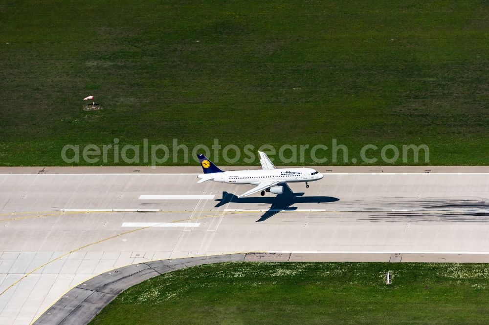 München-Flughafen from the bird's eye view: Passenger aircraft A320 in landing approach for landing at the airport in Muenchen-Flughafen in the state Bavaria, Germany