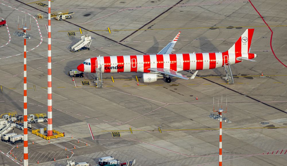 Aerial image Düsseldorf - Red - white striped painted CONDOR AIRBUS A321-200 - passenger aircraft with the identification D-ATCG in the parking position - parking area at the airport in the Lohausen district in Duesseldorf in the Ruhr area in the state North Rhine-Westphalia, Germany