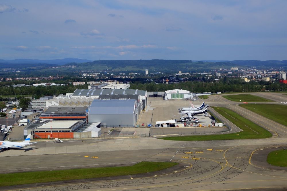 Aerial photograph Saint-Louis - Passenger airplanes in parking position in front of the hangars of Jetaviation at the Euroairport Basle Mulhouse Freiburg in Saint-Louis in Grand Est, France
