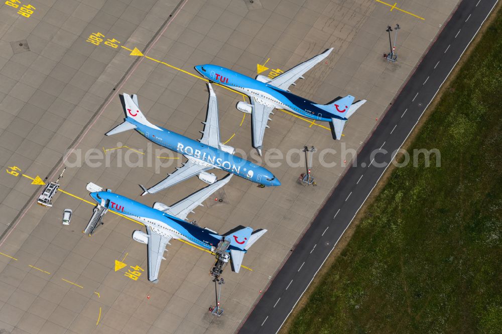 Langenhagen from the bird's eye view: Passenger airplane of Typs Boeing 737-8K5 of the airlines TUI and Robinson in parking position - parking area at the airport in Langenhagen in the state Lower Saxony, Germany