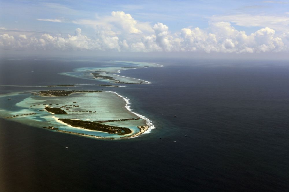 Dharanboodhoo from the bird's eye view: Cumulus clouds overcast Coastal Indian Ocean - island in Dhahran Boodhoo in Central Province, Maldives