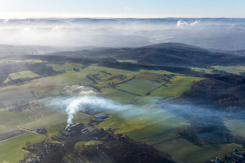Menden (Sauerland) from the bird's eye view: Smoke clouds of a fire and fog over meadows and fields at Menden-Barge airfield in Menden (Sauerland) in the state North Rhine-Westphalia, Germany