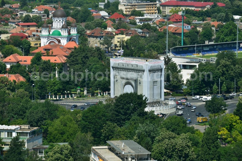 Aerial photograph Bukarest - The restoration and rehabilitation work on the Arcul de Triumf, the triumph arch in the Romanian capital Bucharest in Romania. The landmark on the star-shaped roundabout tapering of Piata Arcul de Triumf is currently covered with a to-scale printed tarpaulin to protect the sandblasting and restoration work