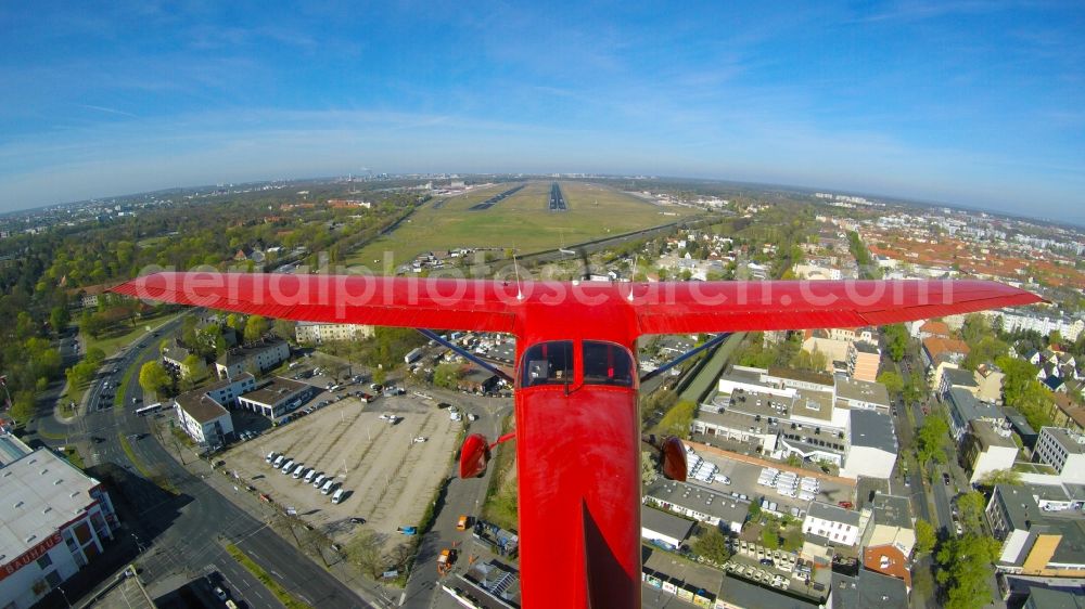 Aerial photograph Berlin - Airplane - red Cessna F 172H of the agency euroluftbild.de with the identification D-EGYC during a low approach over runway 26R in flight over Tegel Airport in Berlin, Germany