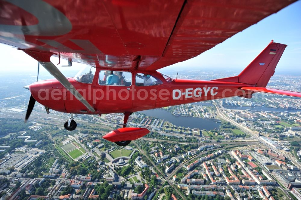 Aerial photograph Berlin - Bright red Cessna 172 D-EGYC of the agency euroluftbild.de in flight over the district Friedrichshain in Berlin, Germany