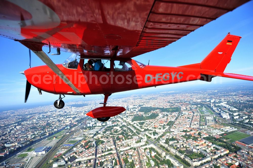 Aerial image Berlin - Bright red Cessna 172 D-EGYC of the agency euroluftbild.de in flight over the district Friedrichshain in Berlin, Germany