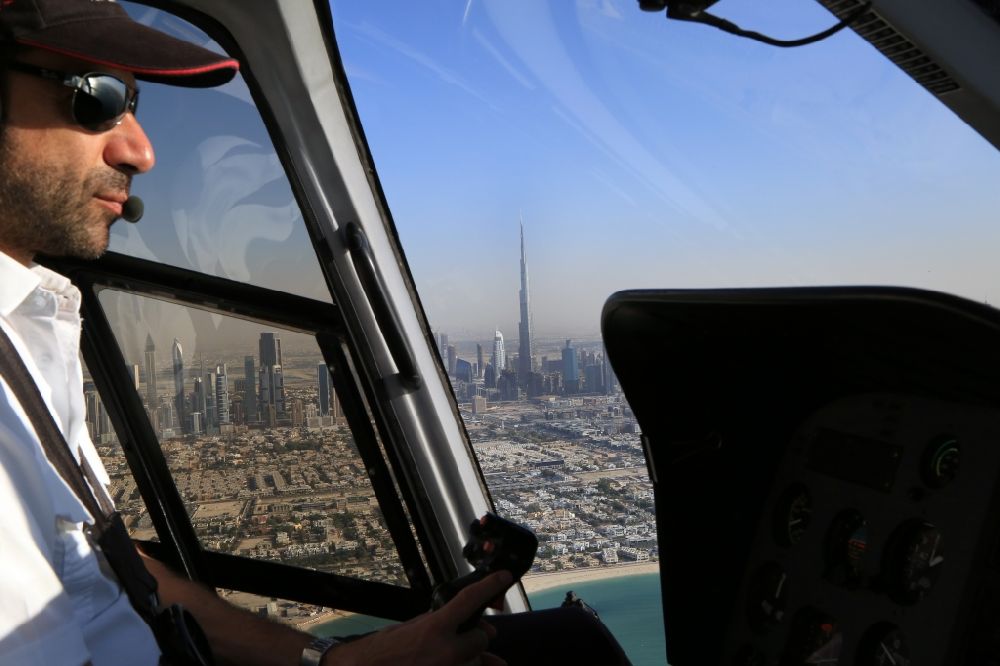 Aerial image Dubai - Sightseeing flight in a helicopter off the coast of Dubai in the United Arab Emirates. The impressive skyline with skyscrapers and the Burj Khalifa, the tallest skyscraper in the world