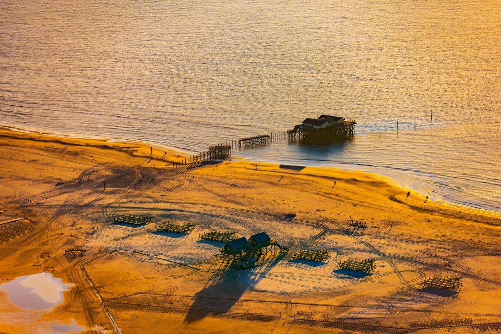 Sankt Peter-Ording from above - Sandy beach landscape on the North Sea coast Pile dwellings restaurants - restaurants in Sankt Peter-Ording in the afterglow with long shadows in Schleswig-Holstein
